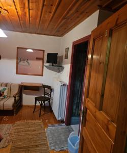 a living room with a table and a chair at Βωλίτης Ξενώνας - Παραδοσιακό Καφενείο Ζαγορίου in Papingo