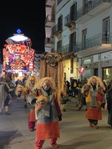 a group of people dressed in bear costumes walking down a street at Casa Nina in Putignano