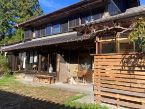 a house with a cat sitting outside of it at Family Homestay Shirokuro Guesthouse in Nakakiri