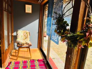 a chair sitting in the doorway of a room at Family Homestay Shirokuro Guesthouse in Nakakiri