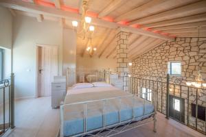 a bedroom with a bed in a room with a wooden ceiling at Villa Irida by Elayan Villas Corfu in Sidari
