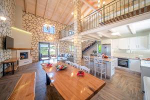 a kitchen and living room with a wooden table at Villa Irida by Elayan Villas Corfu in Sidari