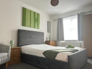 a bedroom with a bed and a chair and a window at Spacious 2 Bed 2 Shower Apartment in Crewe