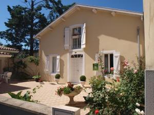 a house with a white door and some flowers at Gîte des graverots in Aire-sur-lʼAdour