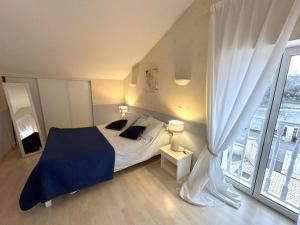 a bedroom with a bed and a large window at Gîte des graverots in Aire-sur-lʼAdour