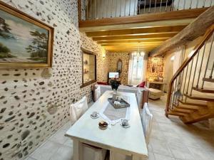 a living room with a table and a staircase at Gîte des graverots in Aire-sur-lʼAdour