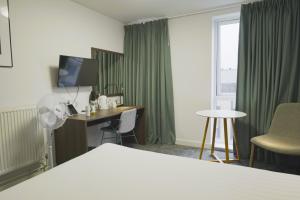 a hotel room with a bed and a desk and a window at Sunley Hotel in Northampton +22 photos