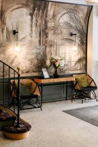 a room with a table and chairs and a wall at Hôtel Paris Neuilly in Neuilly-sur-Seine