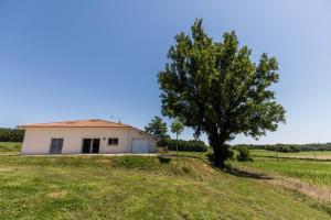 a house in a field with a tree at Juine in Fargues