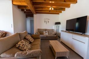 a living room with couches and a flat screen tv at Juine in Fargues