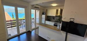a kitchen with a view of the ocean from a balcony at Apartment MiriMore in Hodilje +9 photos