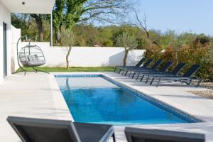 a swimming pool with two chairs and a swing at Villa Sensei in Linardići +42 photos