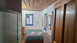a small bedroom with a bed in a room at Βωλίτης Ξενώνας - Παραδοσιακό Καφενείο Ζαγορίου in Papingo