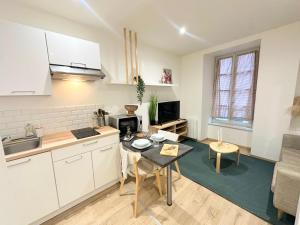 a kitchen and living room with a table in a kitchen at Le Cabrol Hyper centre WIFI 1er étage in Rodez +17 photos