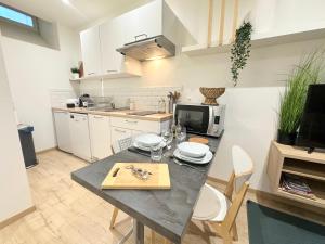 a kitchen with a table and a counter top at Le Cabrol Hyper centre WIFI 1er étage in Rodez