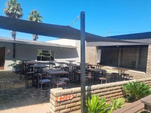 a restaurant with tables and chairs in a patio at Lodge Linga Longa in Queenstown