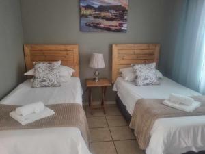 a bedroom with two beds and a table with a lamp at Lodge Linga Longa in Queenstown +31 photos