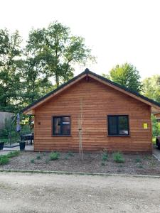 a small log cabin with a small tree at Chalet Liquidambar in Zutendaal