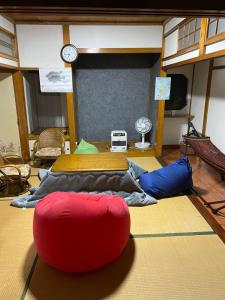 a room with two beds and a red ball on the floor at 釣り宿yasakabase guesthouse in Sado