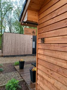 a wooden building with a number on the side of it at Chalet Liquidambar in Zutendaal