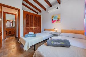 a bedroom with three beds in a room at Villa Can Deyá in Port de Pollensa +13 photos