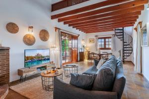 a living room with a couch and a tv at Villa Can Deyá in Port de Pollensa