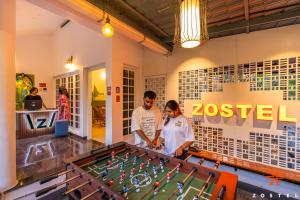 two people standing in front of a pool table at Zostel Munnar in Devikolam