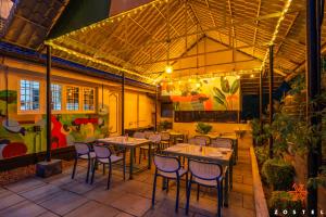 a restaurant with tables and chairs on a patio at Zostel Munnar in Devikolam