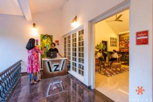 a woman is standing at a counter in a store at Zostel Munnar in Devikolam