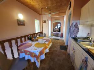 a kitchen with a table in the middle of a room at Mimóza Vendégház - Csaba Vendégház in Balatonszemes
