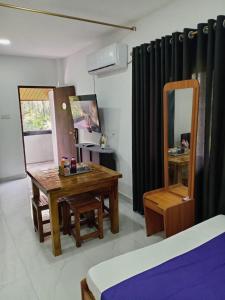 a room with a wooden table and a mirror at Nil Manel Tourist in Anuradhapura
