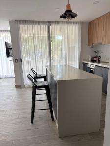 a kitchen with a counter and a stool in a kitchen at Zeus II Pinamar in Pinamar