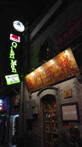 a sign on the side of a building at night at Qianmen Hostel (Beijing Tian'anmen Dashilan) in Beijing