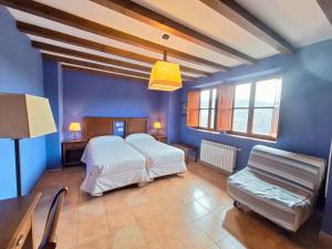a bedroom with a white bed and blue walls at Oceano verde in Cervera de Pisuerga