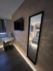 ein Spiegel in einem Zimmer mit einem Bett und einem Schreibtisch in der Unterkunft Rest Inn Edmonton in Edmonton