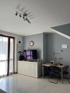 a living room with a tv and a table at House IL CORALLO in Castrezatto