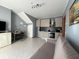 a living room with a couch and a kitchen at House IL CORALLO in Castrezatto