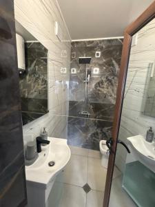 a bathroom with a sink and a shower and a toilet at Панорамна гледка in Leshten