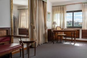 a hotel room with a desk and a window at Hotel Athena in Siena +116 photos