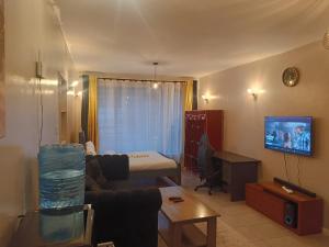 a living room with a couch and a bed at Legatus Cozy Studios B - Ongata Rongai Furnished Apartment with Swimming pool in Nairobi
