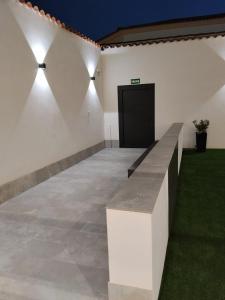 a room with a bench and a wall with lights at Apartamentos EL FONTANAR in Almagro +37 photos