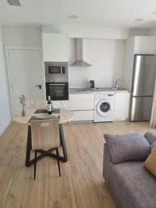 a kitchen and living room with a table and a couch at Apartamentos EL FONTANAR in Almagro