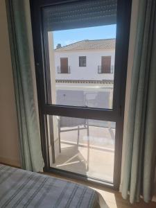 a bedroom window with a view of a building at Apartamentos EL FONTANAR in Almagro