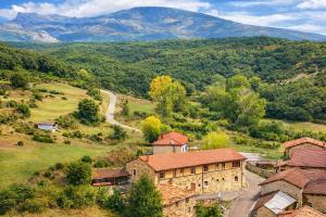 an aerial view of a farm with mountains in the background at Oceano verde in Cervera de Pisuerga