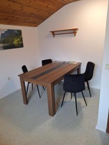 a wooden table and chairs in a room at Ferienwohnung Sankt Josef 2 in Bodensdorf