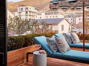 a couch on a balcony with a view of a city at Pineapple House Boutique Hotel in Cape Town