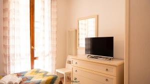 a bedroom with a tv on top of a dresser at I Portici - Cernobbio in Cernobbio