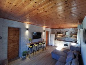 a living room with wooden ceilings and a kitchen with a couch at Kefalonia Olive House private pool in Xi