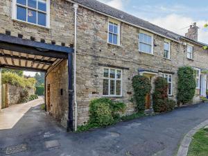 an old brick house with a large garage at Ostlers in Burford