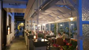 a group of people sitting at tables in a restaurant at Rhein Hotel Bacharach und Stübers Restaurant in Bacharach